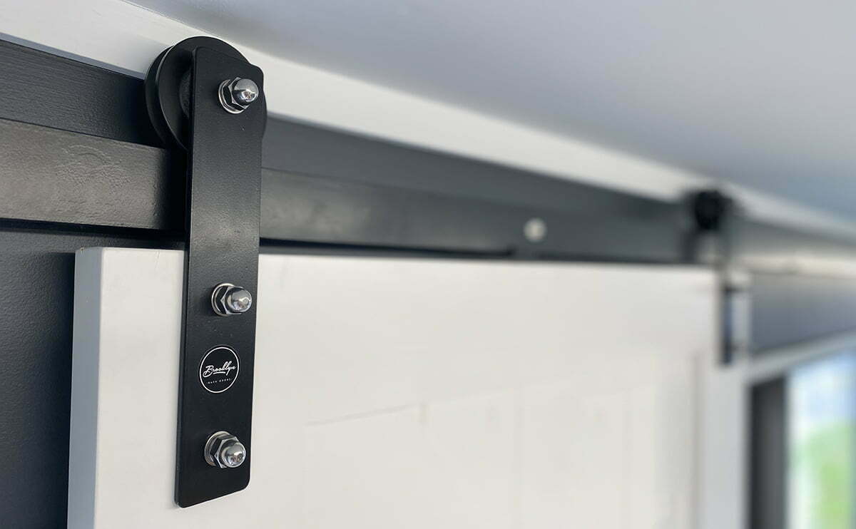 Barn door track and roller fitted above a doorway